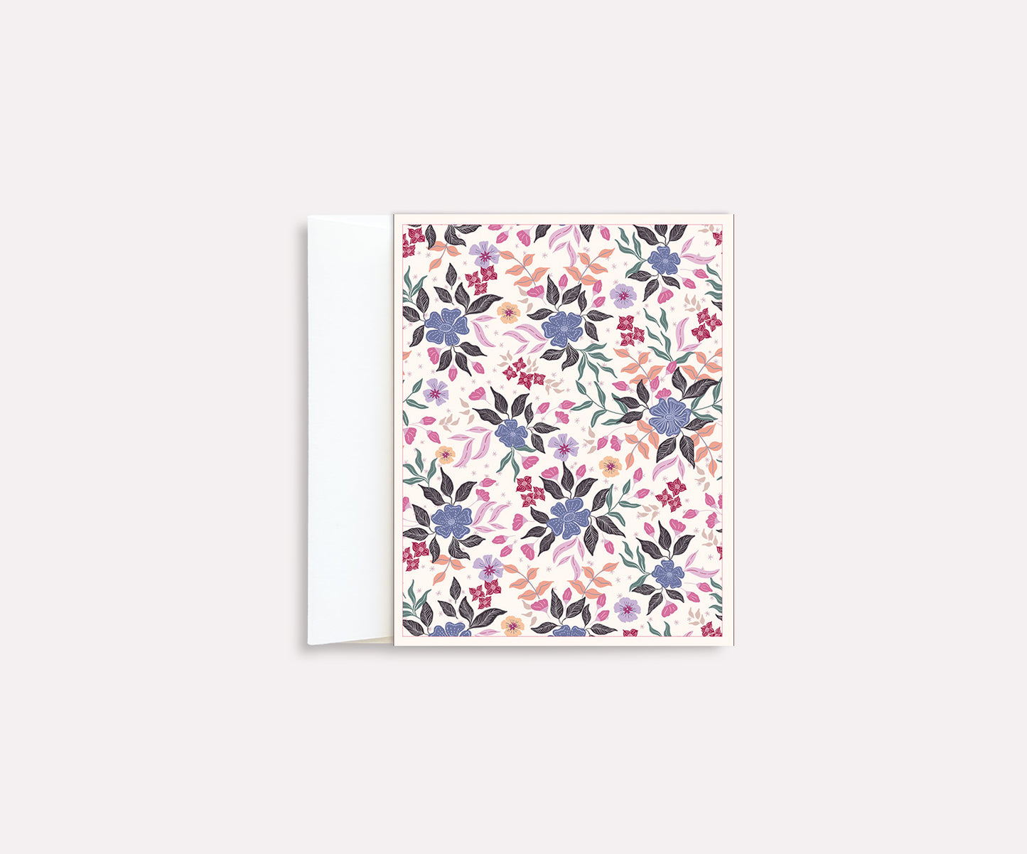 A folded notecard with a vibrant floral pattern on a white background, positioned against a plain background.